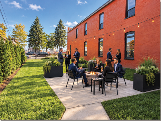 People gathered on the patio alongside the historic brick building