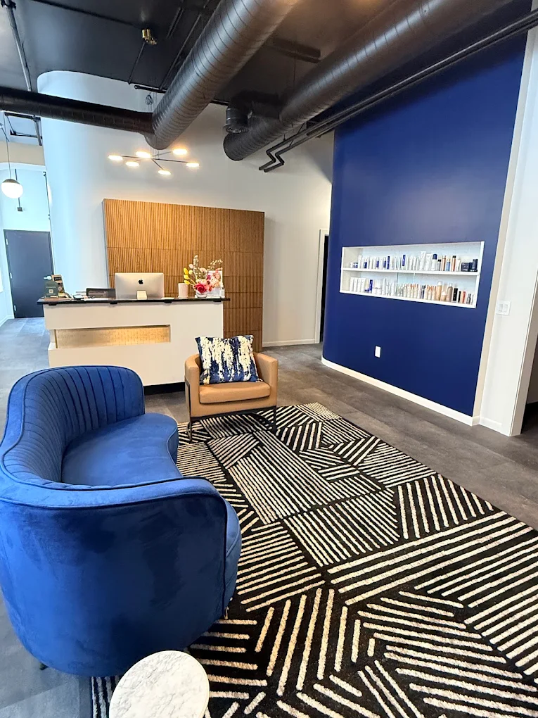 Prim Aesthetics reception inside The Mac Building, with blue seating and a wood feature wall